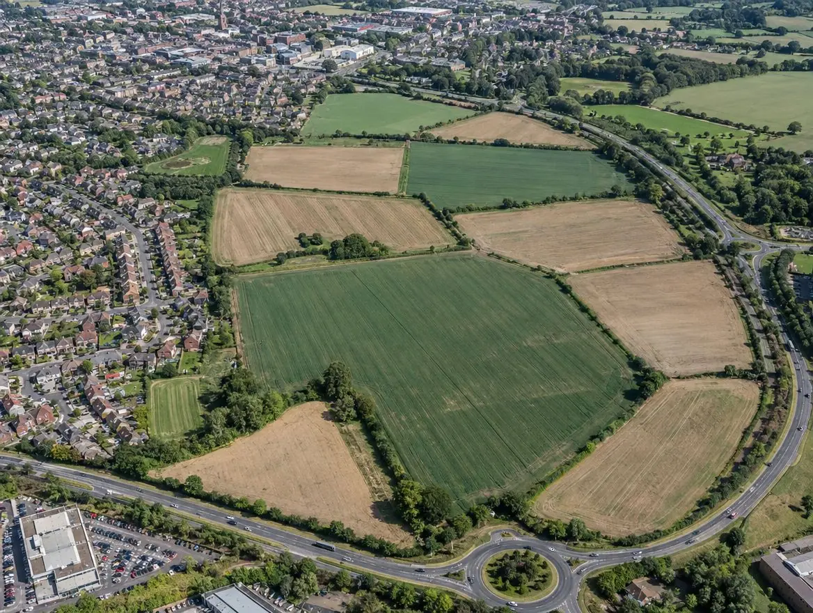 Aerial view of several farm fields between a market town and a ring road